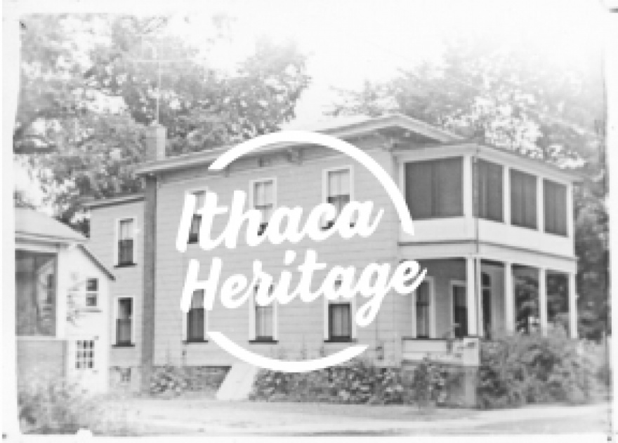 Circular text area that reads ”Ithaca Heritage” overlaid over a black and white image of a house.