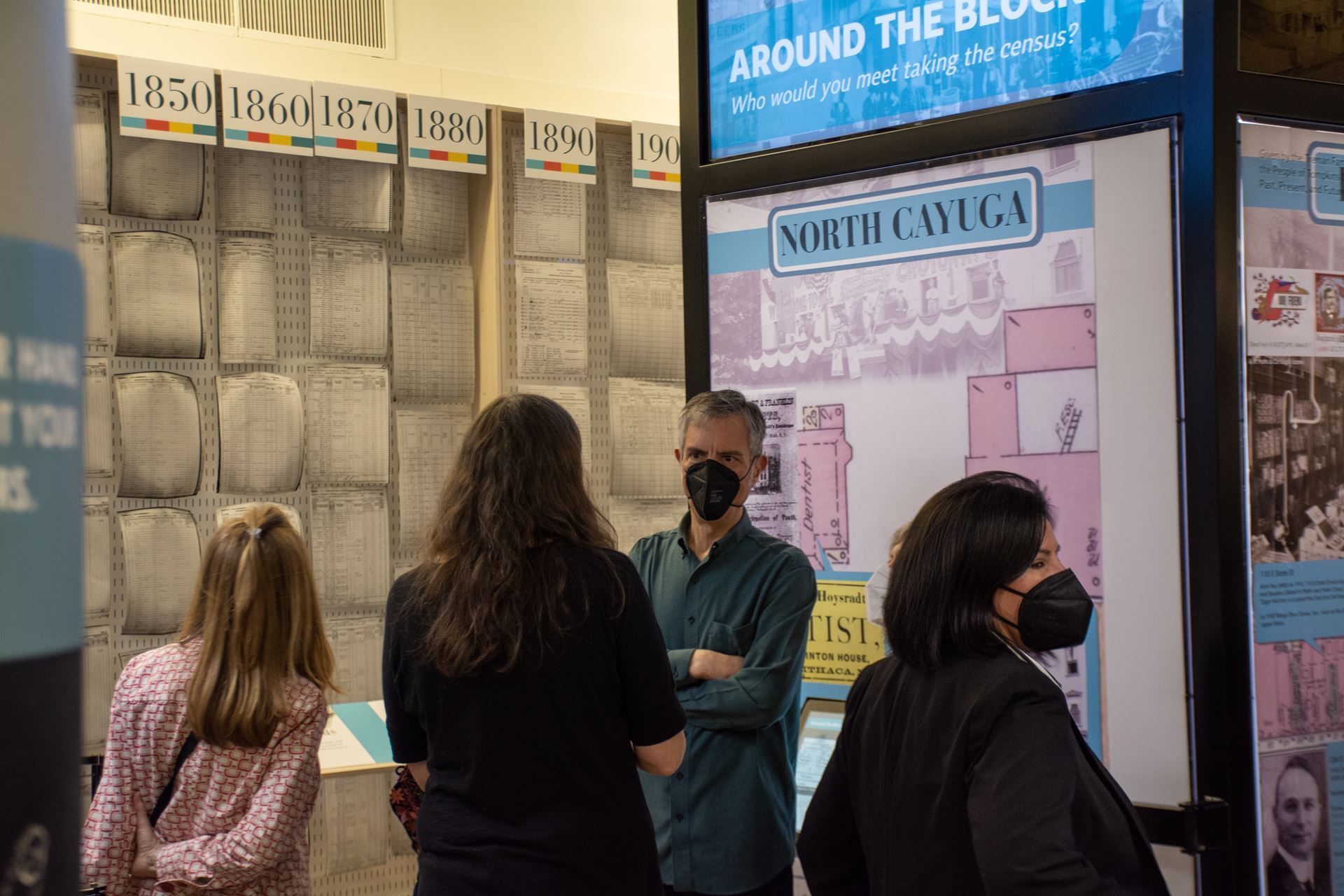 A rectangular image of visitors standing in front of the census exhibit.