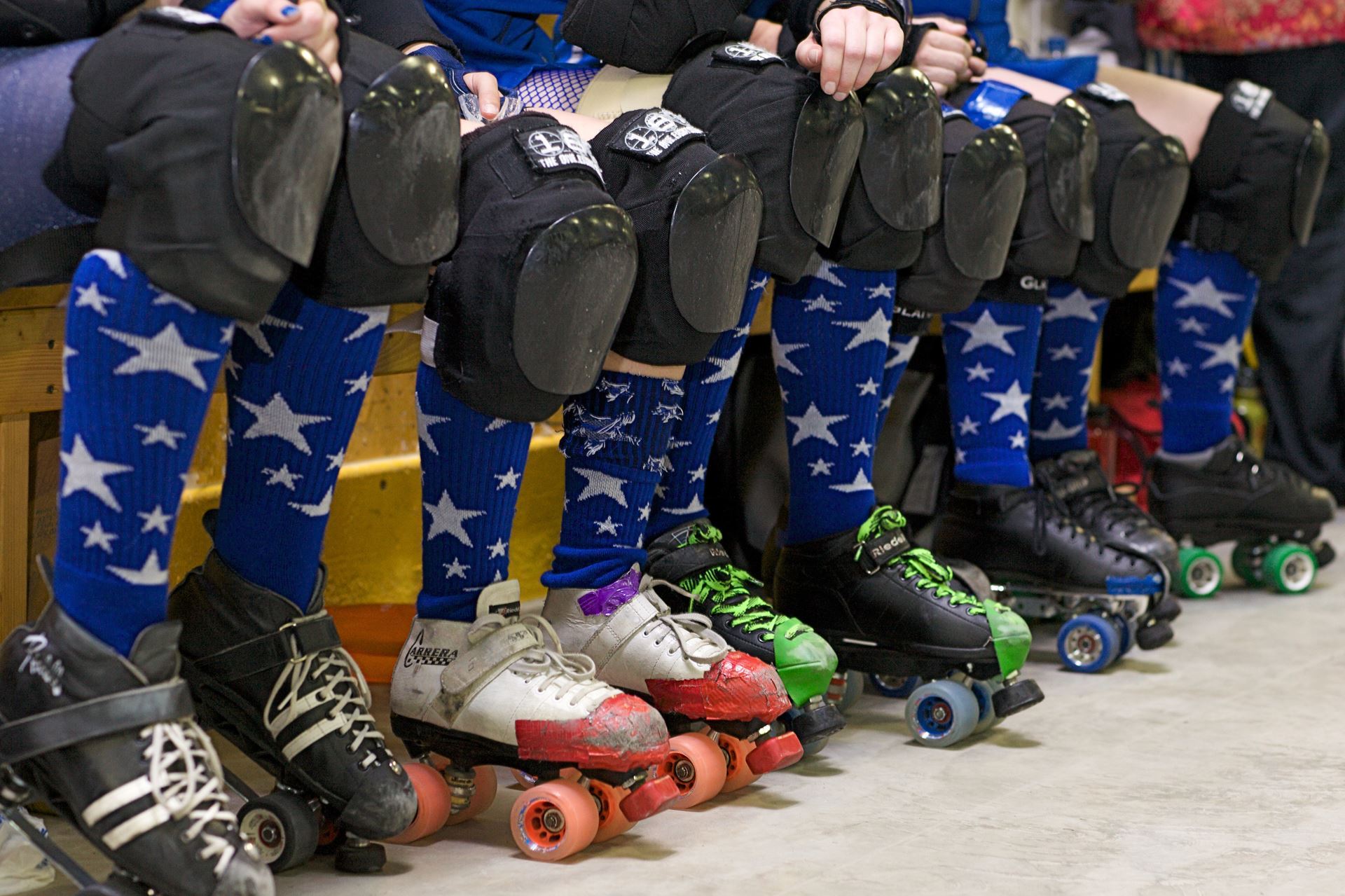 Image of people wearing different roller skates and kneepads.