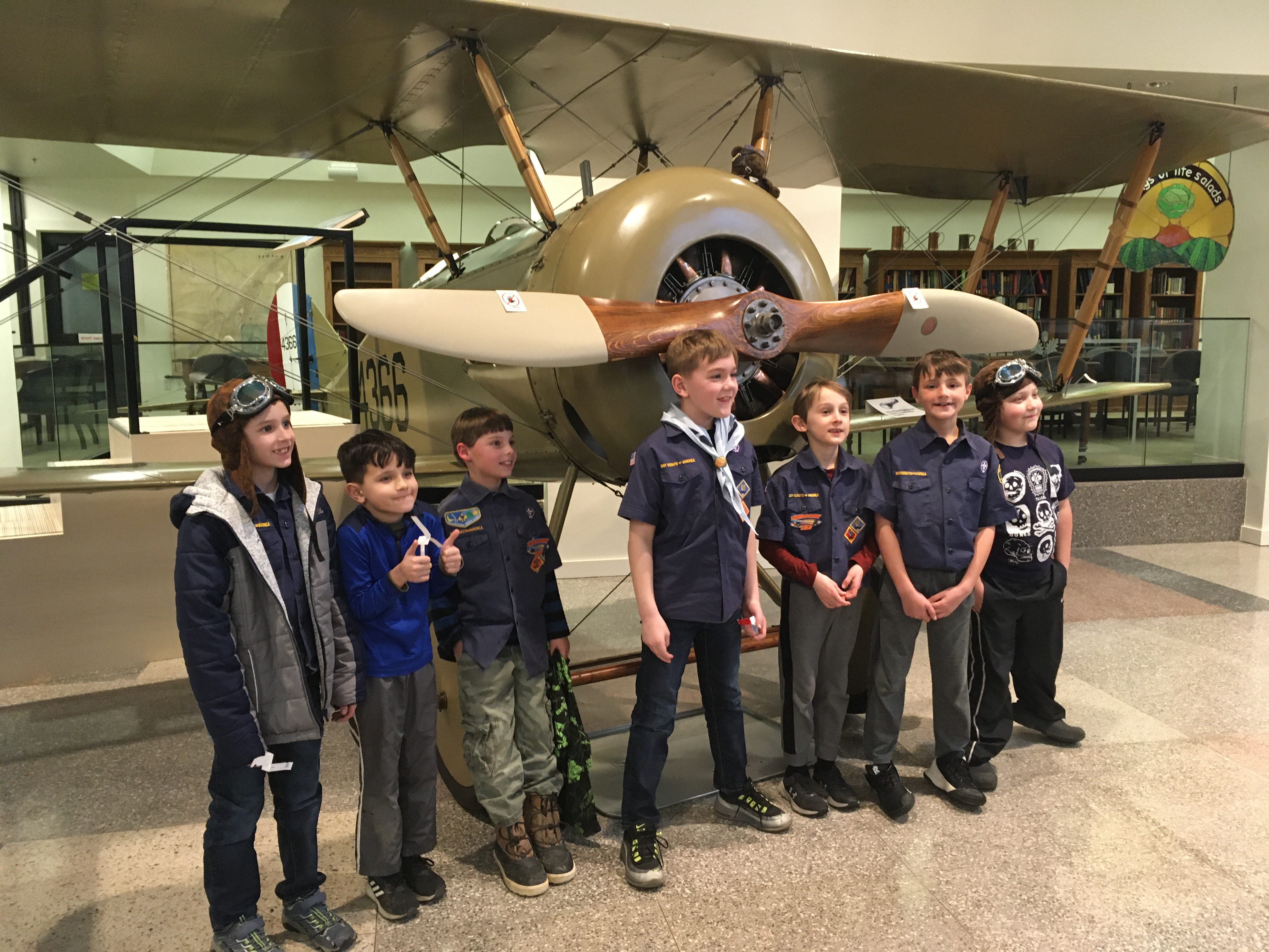 A photo of a group of children standing in front of the Tommy Plane.